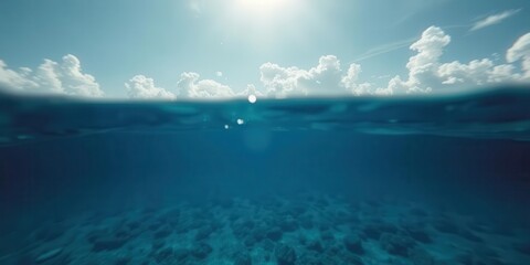 Tranquil blue sea with sunlight penetrating surface, revealing underwater marine life and cloudy sky above, nature, surface