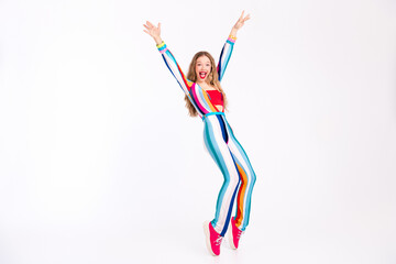 A vibrant young woman in a trendy striped outfit joyfully leaps against a white backdrop, embodying...