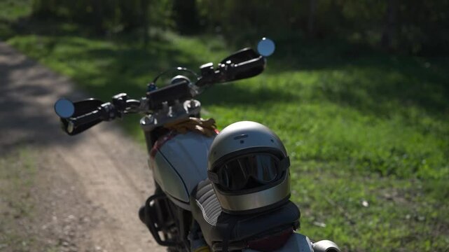 toma detalle de casco de moto sobre el asiento de la motocicleta en el bosque
