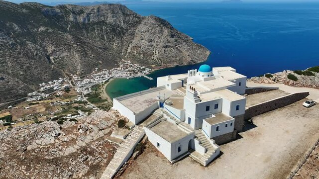 Aerial drone cinematic video with stunning view from uphill chapel of Agios Symeon ovelooking port of Kamares, Sifnos island, Cyclades, Greece