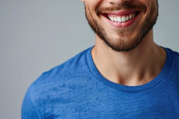 Obraz premium Close up portrait of young smiling handsome guy in blue t shirt isolated on gray background