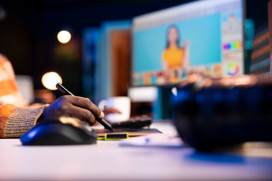 Black remote designer working from well organized home office, retouching photos on dual monitors with editing software. Young man illustrating creative career, using advanced design software.