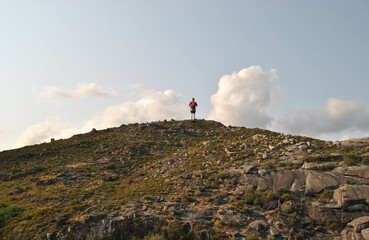 Person climbing a mountain slope, walking, almost reaching the top, success, victory