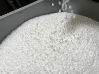  filling a deposit with white plastic pellets, production of plastic parts, plastic injection, spilling of plastic pelets, granules of raw material, horizontal