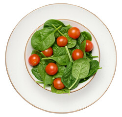 Heap of fresh green spinach leaves and red cherry tomatoes in white plate on isolated background