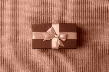 Gift in a box on knitted fabric background. Birthday holiday concept. Top view, flat lay....