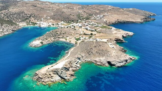 Aerial drone cinematic video of peninsula near picturesque fishing village of Faros and clear water beach of Fasolou, Sifnos island, Cyclades, Greece