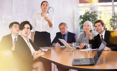 Group of diverse business people attending meeting in conference room, discussing work plan