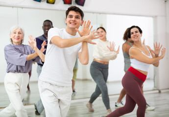 Naklejka premium Group of positive people practicing energetic lindy hop movements at a dance school in a lesson