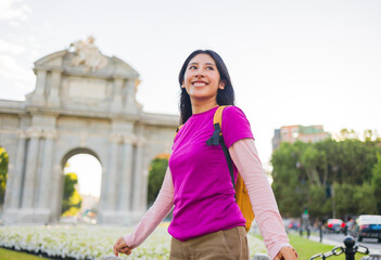 Young peruvian student exploring madrid's Puerta de Alcala near retiro park