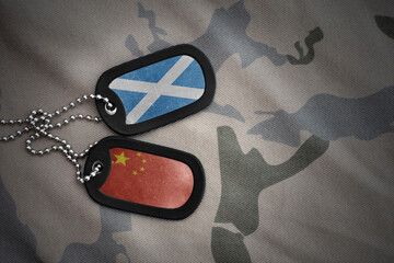 vintage army blank, dog tag with flag of scotland and china on the khaki texture background....