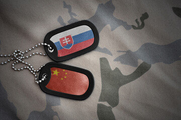 vintage army blank, dog tag with flag of slovakia and china on the khaki texture background....