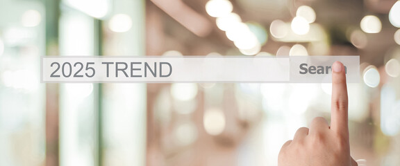 Businesman hand touching 2025 trends search bar over blur office background, banner, SEO 2022...