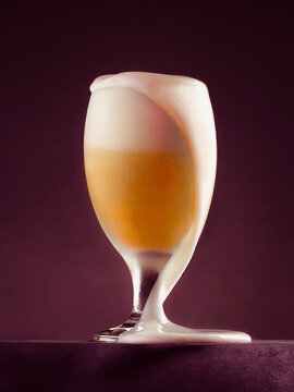 Overflowing Beer Glass on a Dark Background