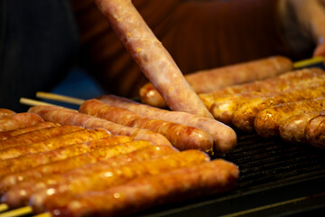 Golden brown sausages are neatly lined up on the grill