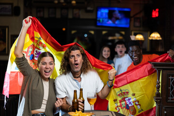 Happy fans celebrating the victory of Spanish team in the bar