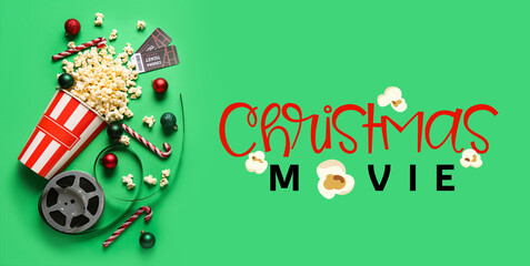 Bucket of popcorn with film reel and Christmas decor on green background