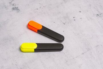 Brightly colored text markers for highlighting and drawing on a marbled background.