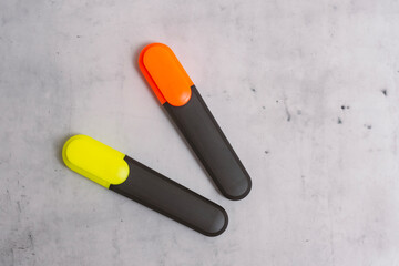 Brightly colored text markers for highlighting and drawing on a marbled background.