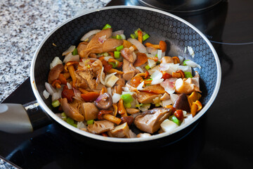 Close-up of delicious fried mushrooms with onion in a frying pan