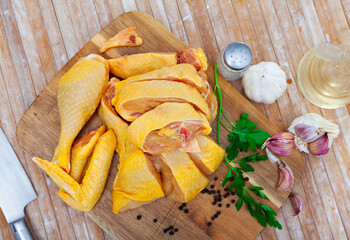 Ingredients for cooking. Sliced fresh raw farmer chicken with herbs and garlic on wooden surface