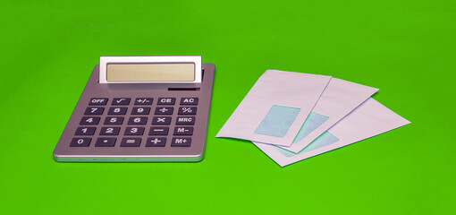 White envelopes with bills next to a calculator