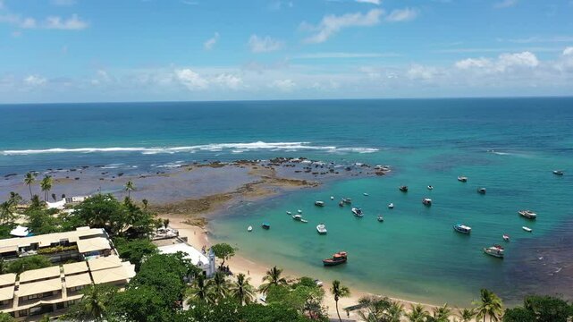 Fantastic aerial view of Praia do Forte beach with small boats turquoise waters and a cute village near Salvador. Praia do Forte, Bahia, Brazil 