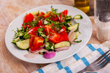 Refreshing salad with chopped tomatoes, cucumbers and sliced onion