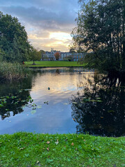 Obraz premium Serene Pond with Historic Building in the Background