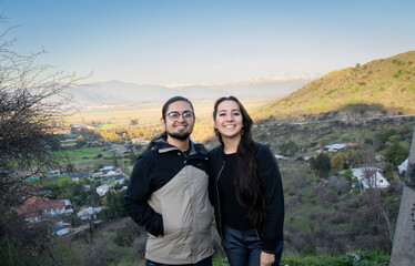 latin travelers couple with a view of the andes mountain range