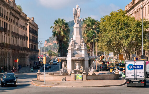 Barcelona, Catalonia, Spain - 08 04 2023: Font del Geni Catala statue on Pla del Palau square of Av. del Marques de l'Argentera street in Barcelona with Montjuic hill in the background