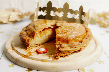 One cut royal galette with a crown and a surprise gift on the table.