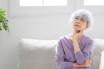 ソファーに座っているシニア女性	
