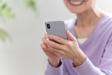 スマートフォンを操作しているシニア女性	
