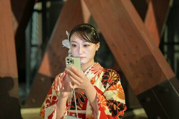 A Japanese woman in her 20s, wearing a red kimono (hakama), a staple for Japanese university...
