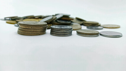 A detailed macro shot of stacked coins arranged on a white background. Suitable for themes of finance, economy, savings, investment, and monetary concepts.