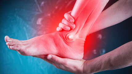 close up photo of a person holding a sore ankle