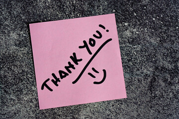 Thank you written on a post-it or note.