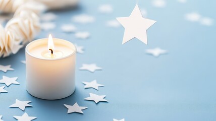 Lit candle with paper stars on blue background