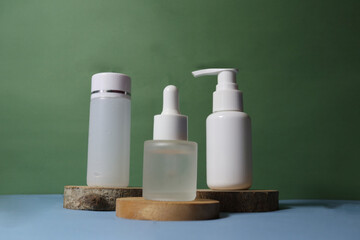unbranded cosmetic bottles for skincare product promotion, with green background and wooden podium and flowers around it