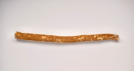One piece of siwak wood for dental care isolated on horizontal plain background.