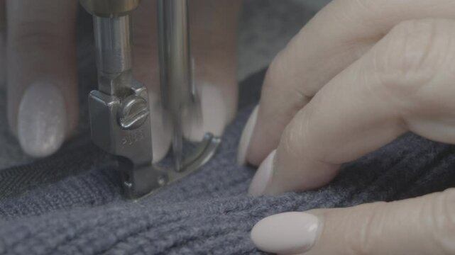 Close up of hands on the sewing maching while sewing