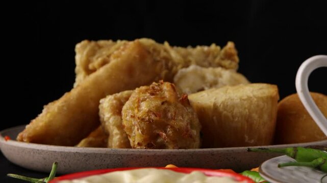 close up on dipping fried tofu or tahu goreng in the mayonnaise with a black background. famous Indonesian snack
