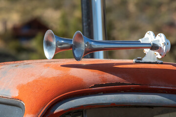 Shiny chrome air horns on an old orange truck