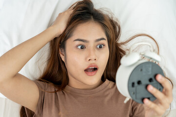Shocked Asia young woman looking at clock alarm, lady is late appointment or work or class study,...
