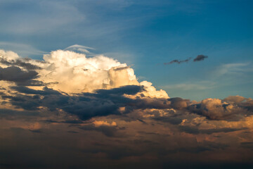 Bright sunset with setting sun behind vivid orange and yellow clouds