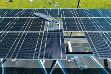 Damaged by hurricane wind photovoltaic solar panels mounted on parking lot canopy roof for...