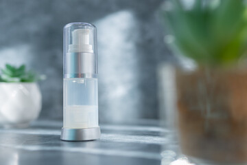 transparent spray bottle standing on a cement surface, sunblock, beauty concept