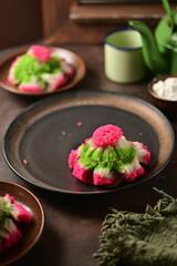 Kue Bikang is a traditional Indonesian flower-shaped cake made from rice flour, coconut milk, and sugar. It's soft, fluffy, and slightly sweet, often in vibrant colors.