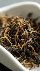 Neatly arranged dried tea leaves for various refreshing beverages in a white dish